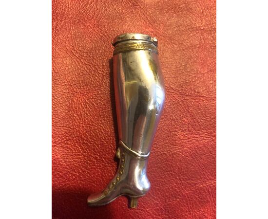 Scatolina portafiammiferi in metallo con dorature raffigurante gamba femminile.