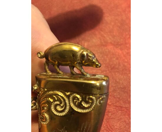 Brass matchbox in the shape of a horn with pig. Date 1897.     