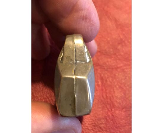 Scatolina portafiammiferi in metallo a forma di valigetta.