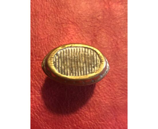 Scatolina portafiammiferi in bronzo a forma di botte schiacciata.
