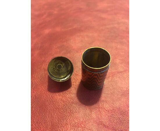 Cylindrical brass matchbox with geometric upholstery decorations.Vesta, England.     