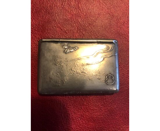 Metal matchbox in the shape of a purse-wallet with art-nouveau floral decorations.     