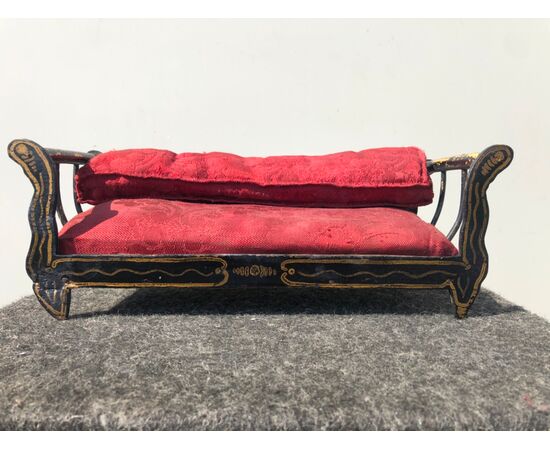 Wooden sofa model with gold decorations.     