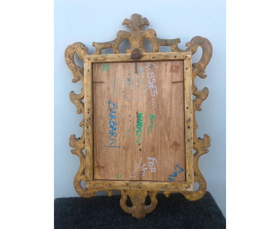 Carved, engraved and carved wooden frame with rocaille motifs.     