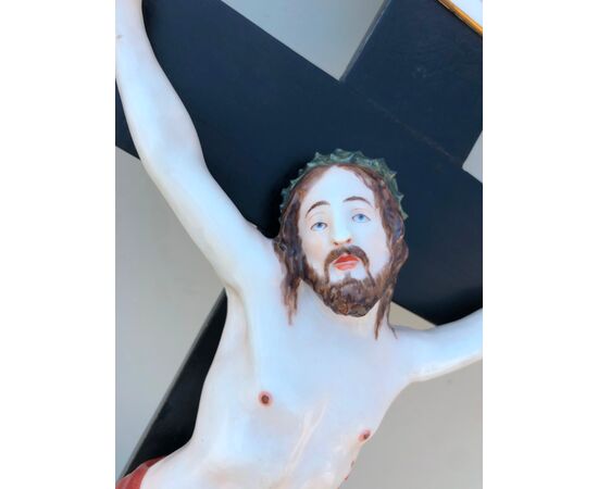 Cristo- acquasantiera in porcellana su croce ebanizzata.Manifattura Ginori.