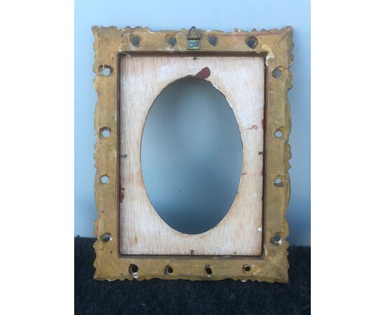 Carved and gilded wooden frame with applied oval interior.     