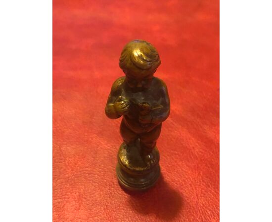 Bronze seal depicting a child holding a bird in his hand.     