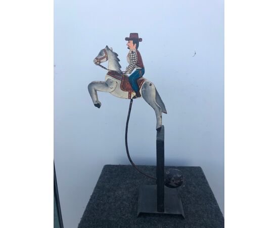 Toy model in painted iron with tilting counterweight depicting a man on horseback.     