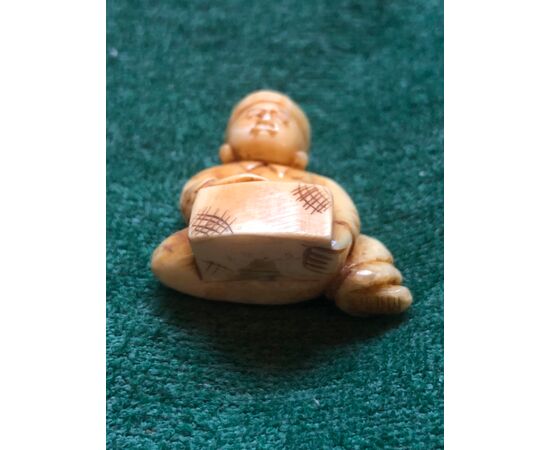 Ivory netsuke &#39;with seated figure with wooden log.Japan.     