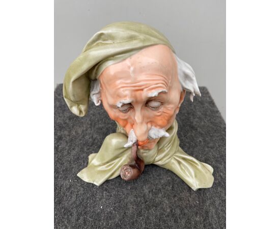 Scultura in porcellana raffigurante testa maschile con cappello e pipa.Giuseppe Cappe’ ( non firmata).