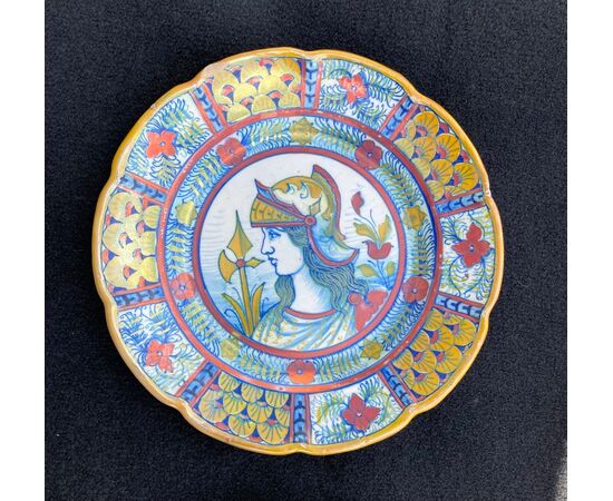 Sette piatti in maiolica decorati a lustro al terzo fuoco con profilo di guerrieri e motivi vegetali stilizzati.Gualdo Tadino.