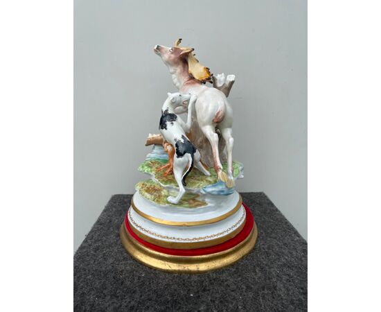 Polychrome porcelain group depicting a hunting scene with a dog attacking a deer.     