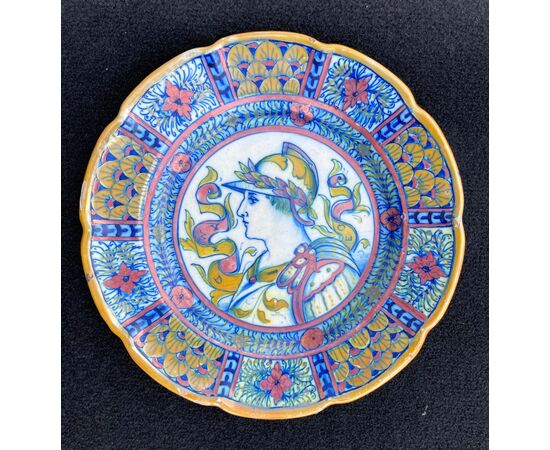 Sette piatti in maiolica decorati a lustro al terzo fuoco con profilo di guerrieri e motivi vegetali stilizzati.Gualdo Tadino.