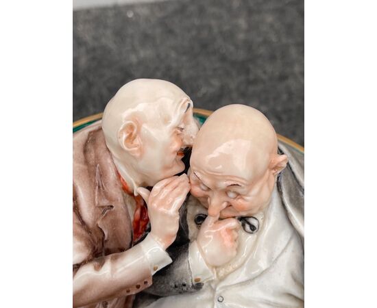 Scultura in porcellana caricaturale raffigurante coppia di amici che si parlano nell’orecchio.Giuseppe Cappe’.