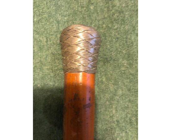 Stick with braided silver knob and rattan cane.     
