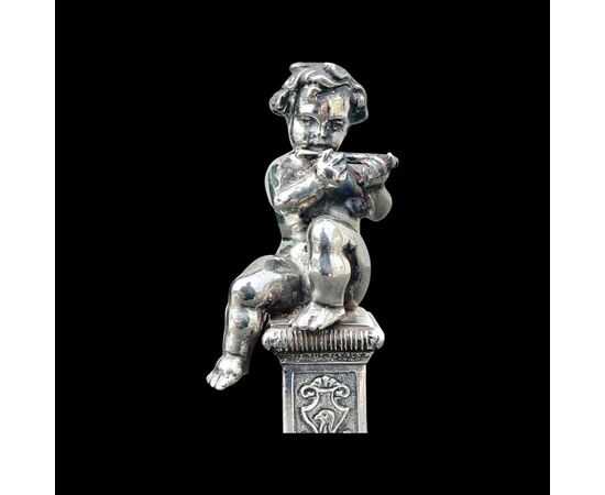 Piccola scultura in argento pieno raffigurante bimbo musicante.Italia.