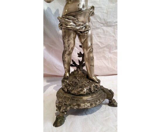 Nickel silver candlestick signed by the artist depicting cupid from the late 19th century