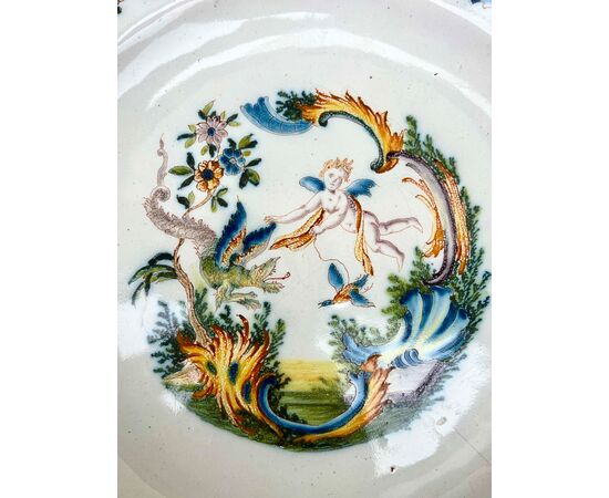 Majolica plate with lobed brim and rocaille motif decoration with angel, fantastic animals and plant motifs. Turin.     