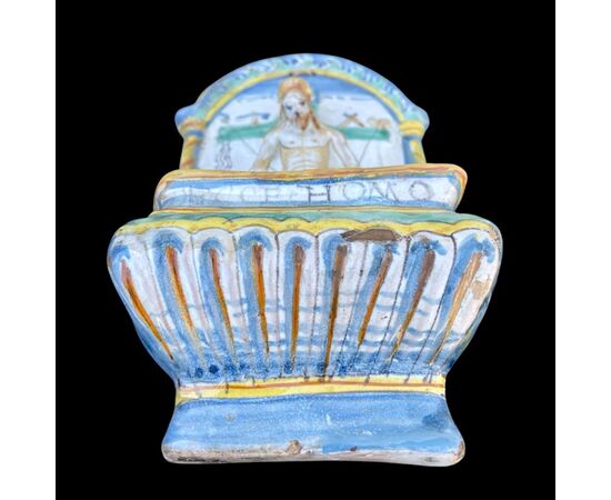 Holy water stoup in polychrome majolica with depiction of Christ and symbols of the passion.Cup with inscription &#39;Ecce homo&#39; and stylized vegetal and geometric decorations.Deruta.     