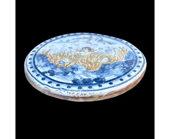 Round tile in majolica decorated with a historiated motif &#39;sinners in hell&#39;.Manufactured by Francesco Vicchi.Faenza.     