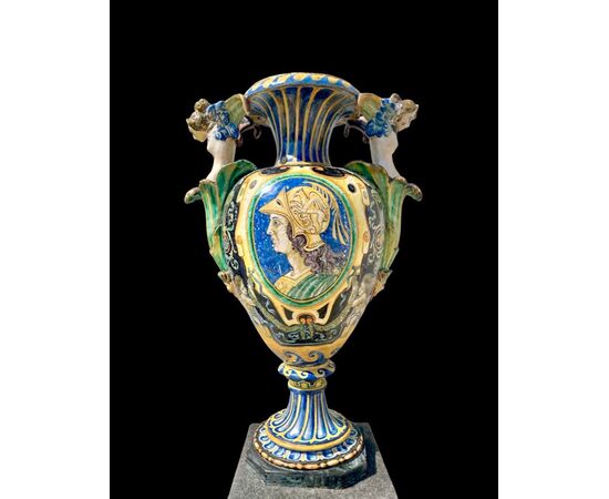 Large majolica vase with lateral handles in the shape of winged figures. Decorated with inscription: Horace defeated the Sabines and medallion with a male profile. Manufacture by Berardino Pepi. Siena.     