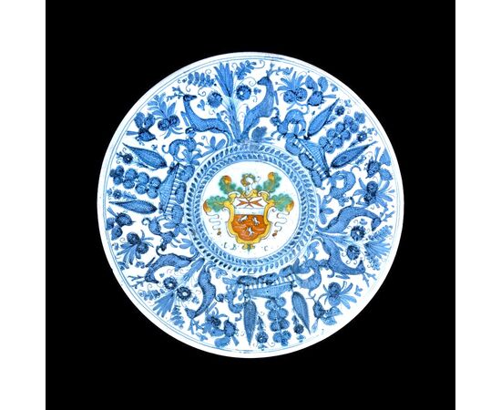 Majolica cutting board with naturalistic calligraphic decoration in turquoise with central medallion with noble coat of arms.     
