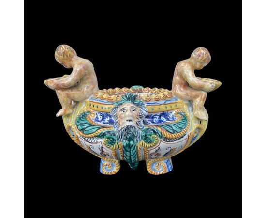 Salt cellar in polychrome majolica with Raphaelesque decoration, plant motifs and masks with a couple of characters holding shells.Molaroni manufacture.Pesaro     