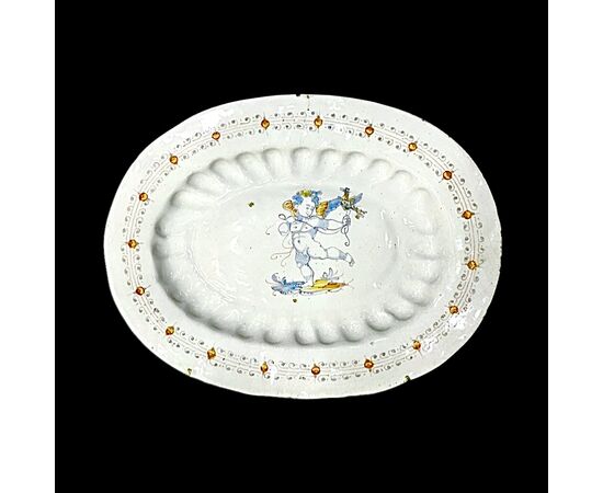 Piatto - vassoio ovale in maiolica baccellata a decoro compendiario con figura di angelo con uccello.Manifattura di Deruta.